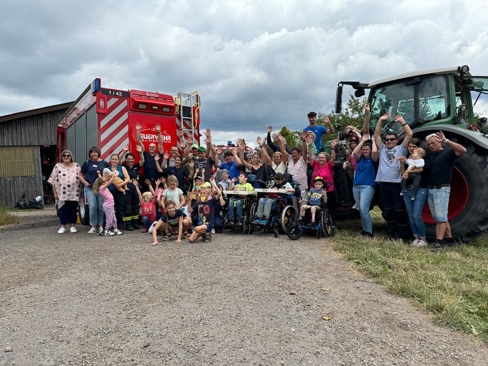 Gruppenfoto mit Feuerwehrauto und Bulldog