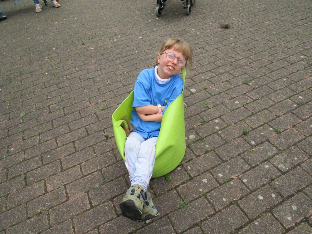 Kind sitzt in einem Eimer